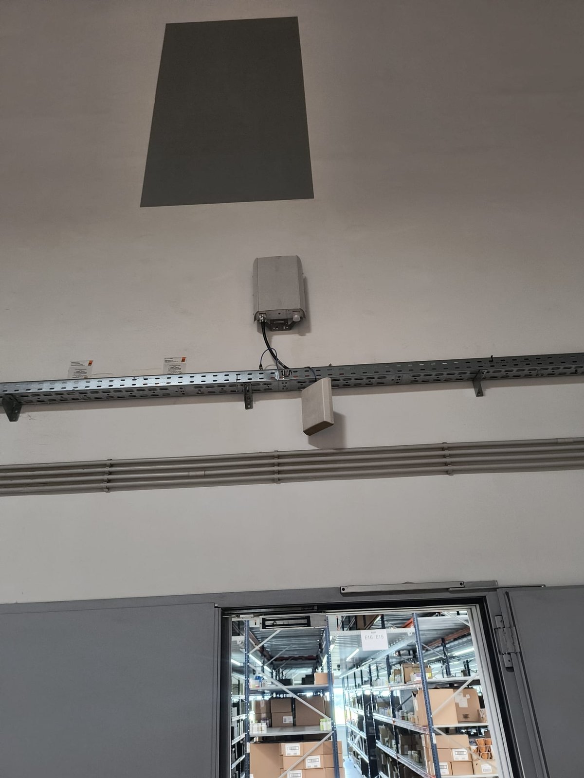 Antenă DAS montată deasupra rafturilor unui depozit logistic