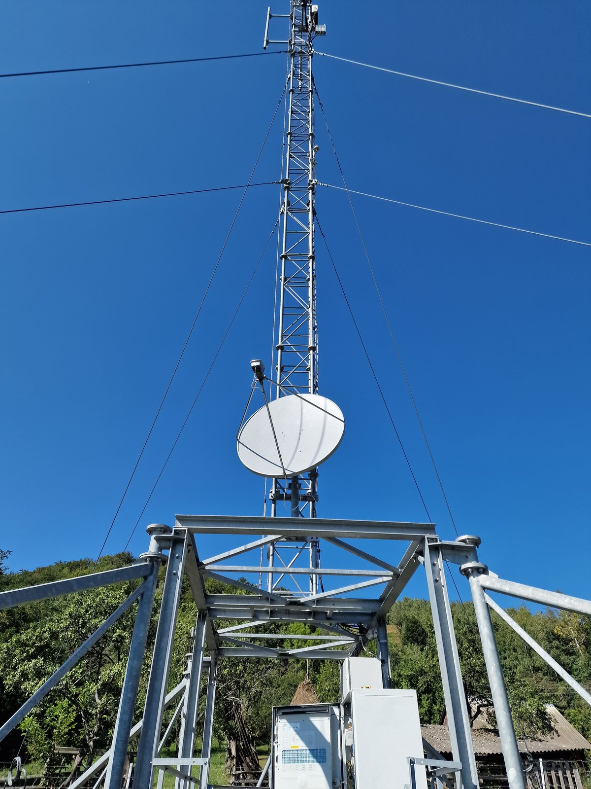 Antenă VSAT instalată pe un pilon zăbrelit, pe un site montan
