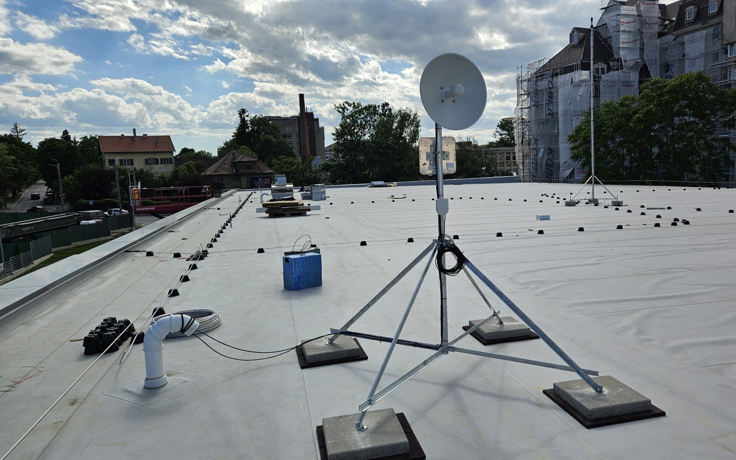 Antenă de radioreleu pe trepied balastat, instalată pe acoperișul unui magazin