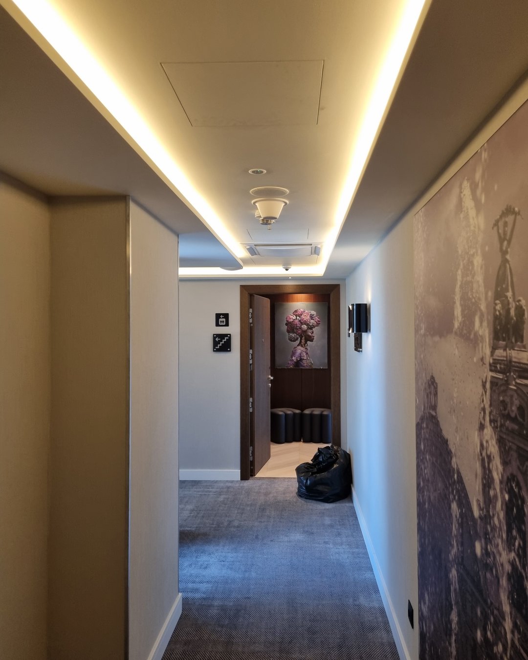 Antenă DAS omnidirecțională pe tavanul unui coridor de hotel, lângă un difuzor încastrat