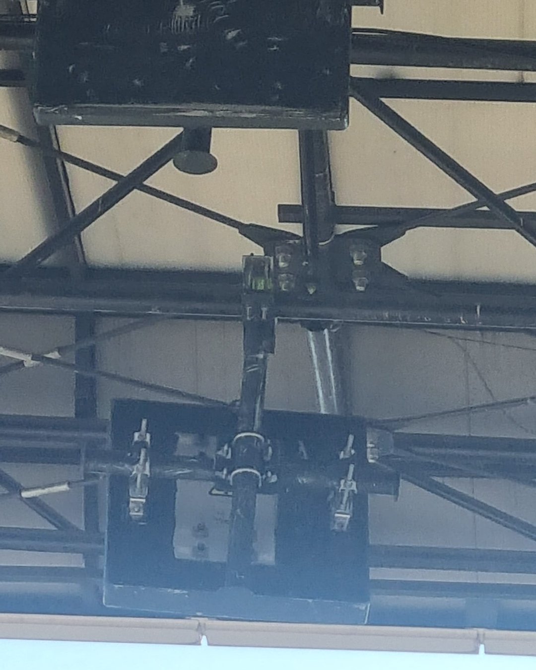Detaliu al unei antene de stadion fixate pe o placă metalică neagră, prinsă de structura acoperișului