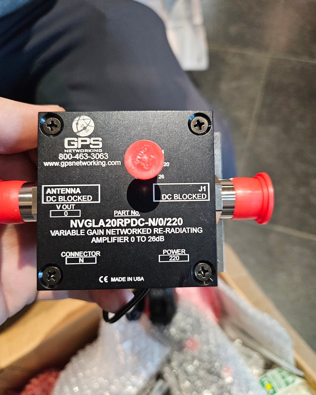 Eticheta unui amplificator re-radiant GPS cu câștig variabil 0-26 dB, ținut în mână la instalare