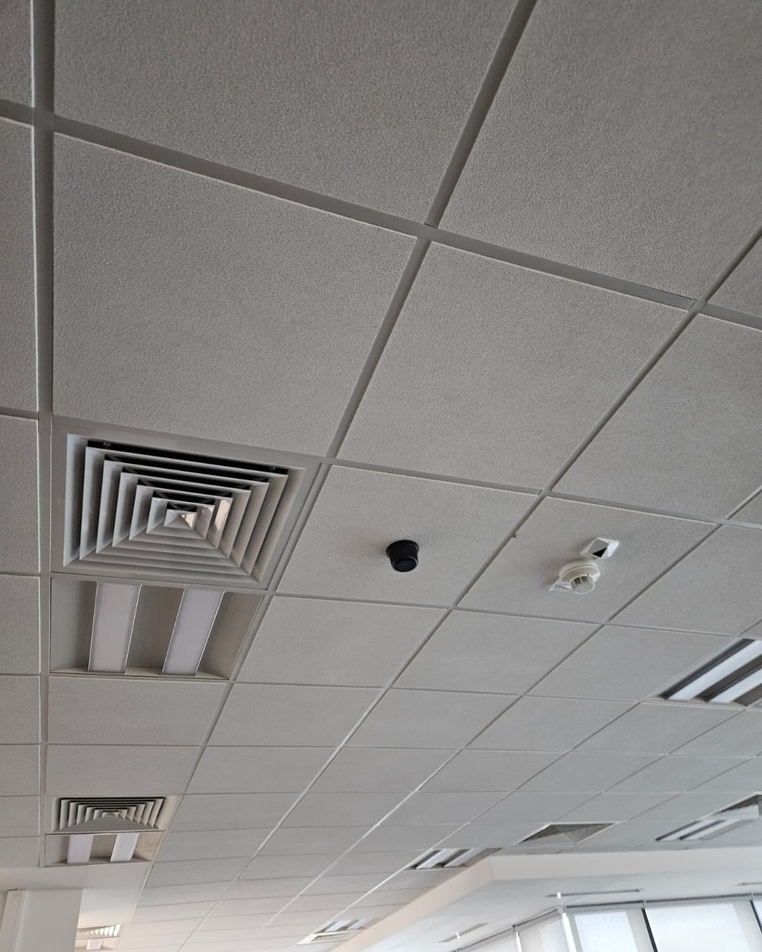 Antenă GPS re-radiantă montată pe tavanul casetat al unui birou open-space
