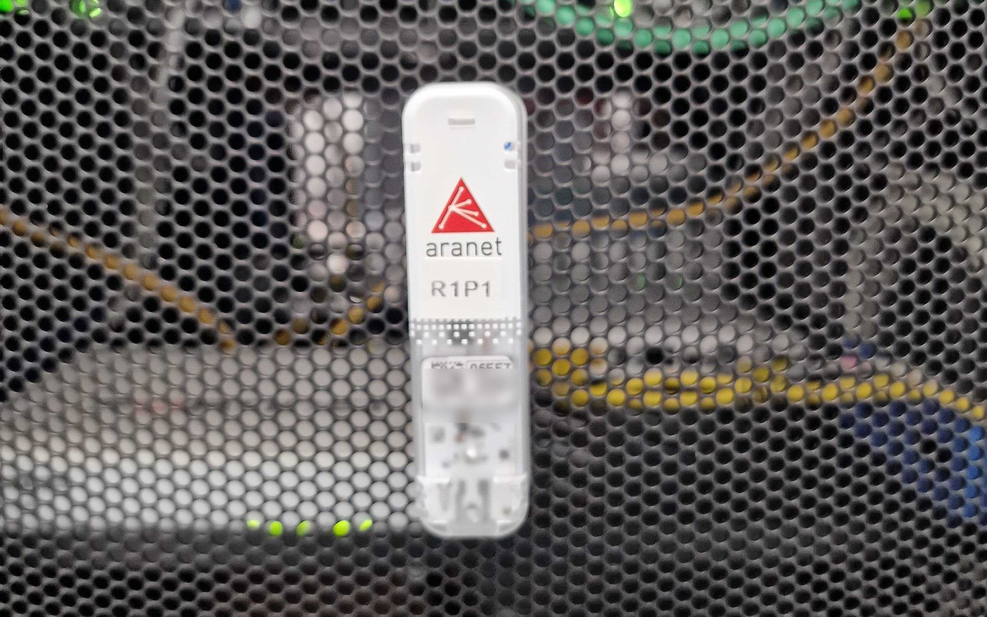 Senzor wireless Aranet montat pe ușa perforată a unui rack de centru de date