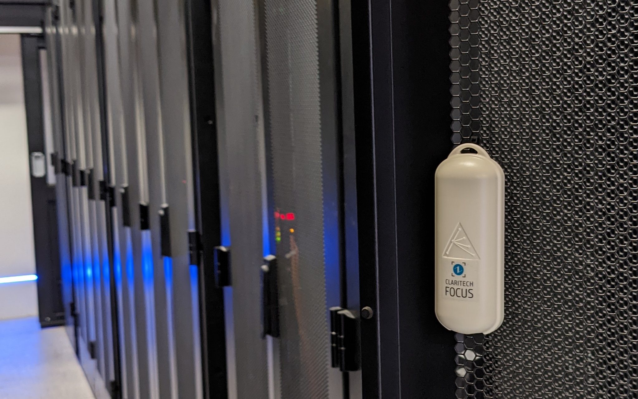 Senzor wireless Claritech FOCUS montat pe ușa unui rack, într-un data center