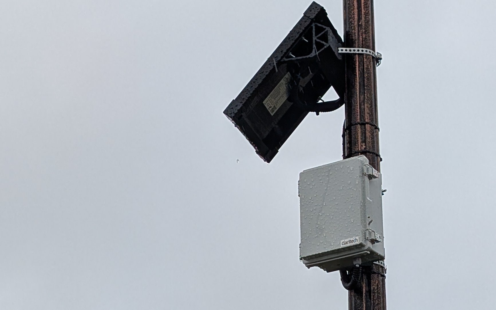 Solar-powered noise monitoring station mounted on a lighting pole