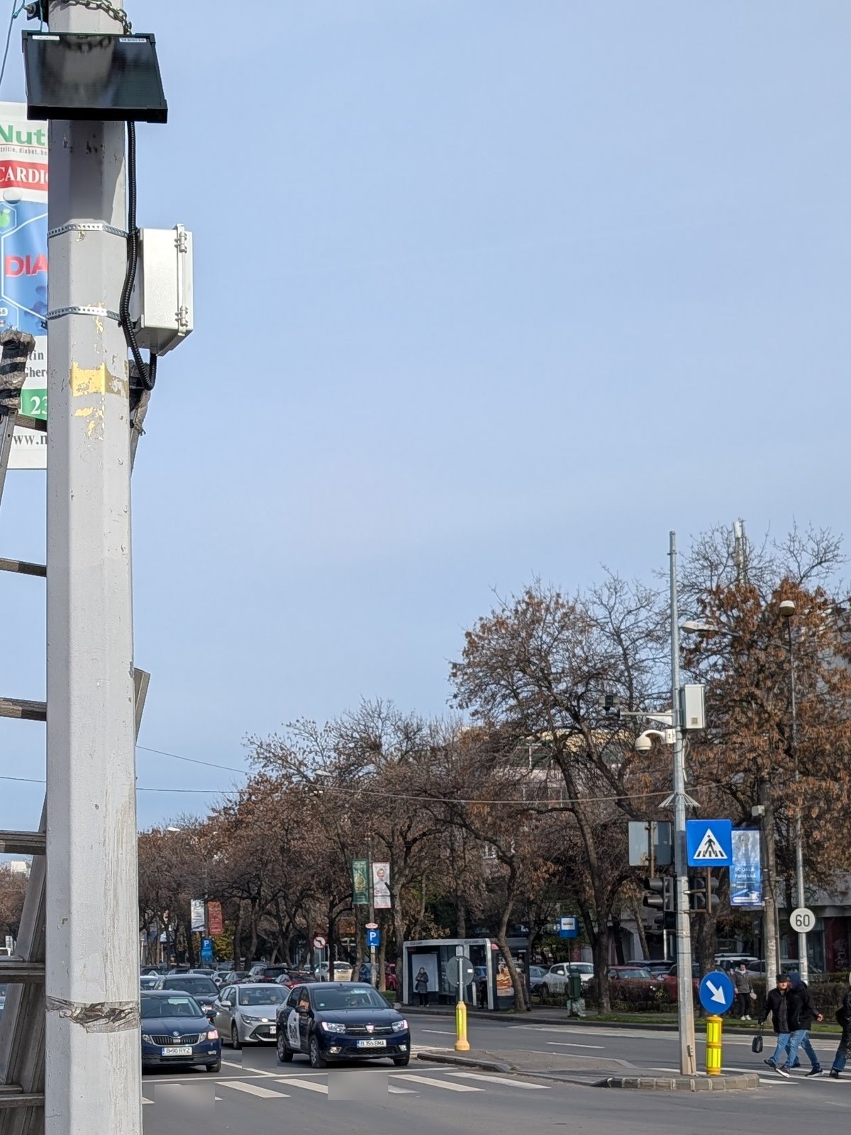 Noise measurement station mounted on a pole at an intersection with a pedestrian crossing