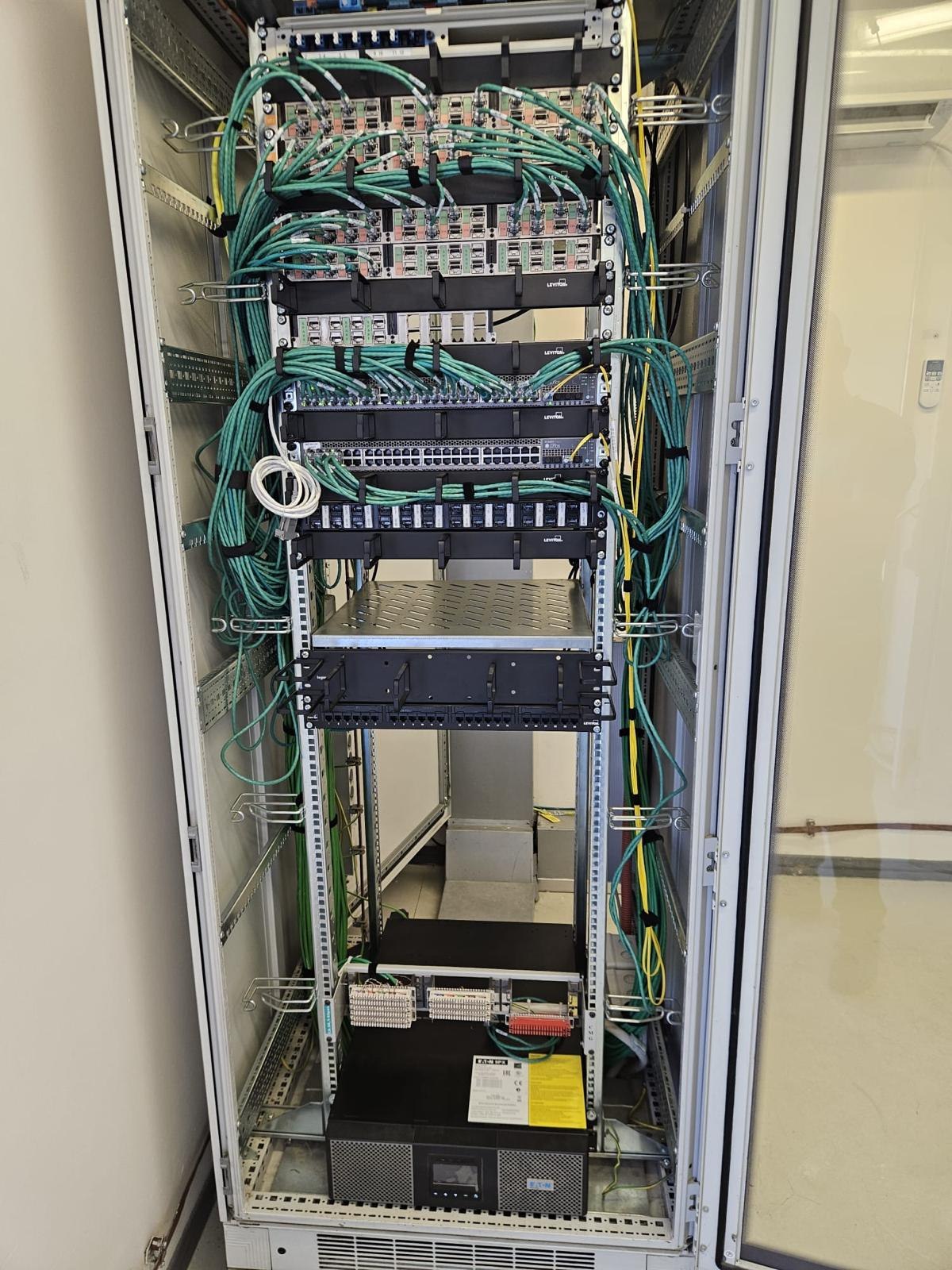 Open distribution rack with a patch field and organized green patch cords