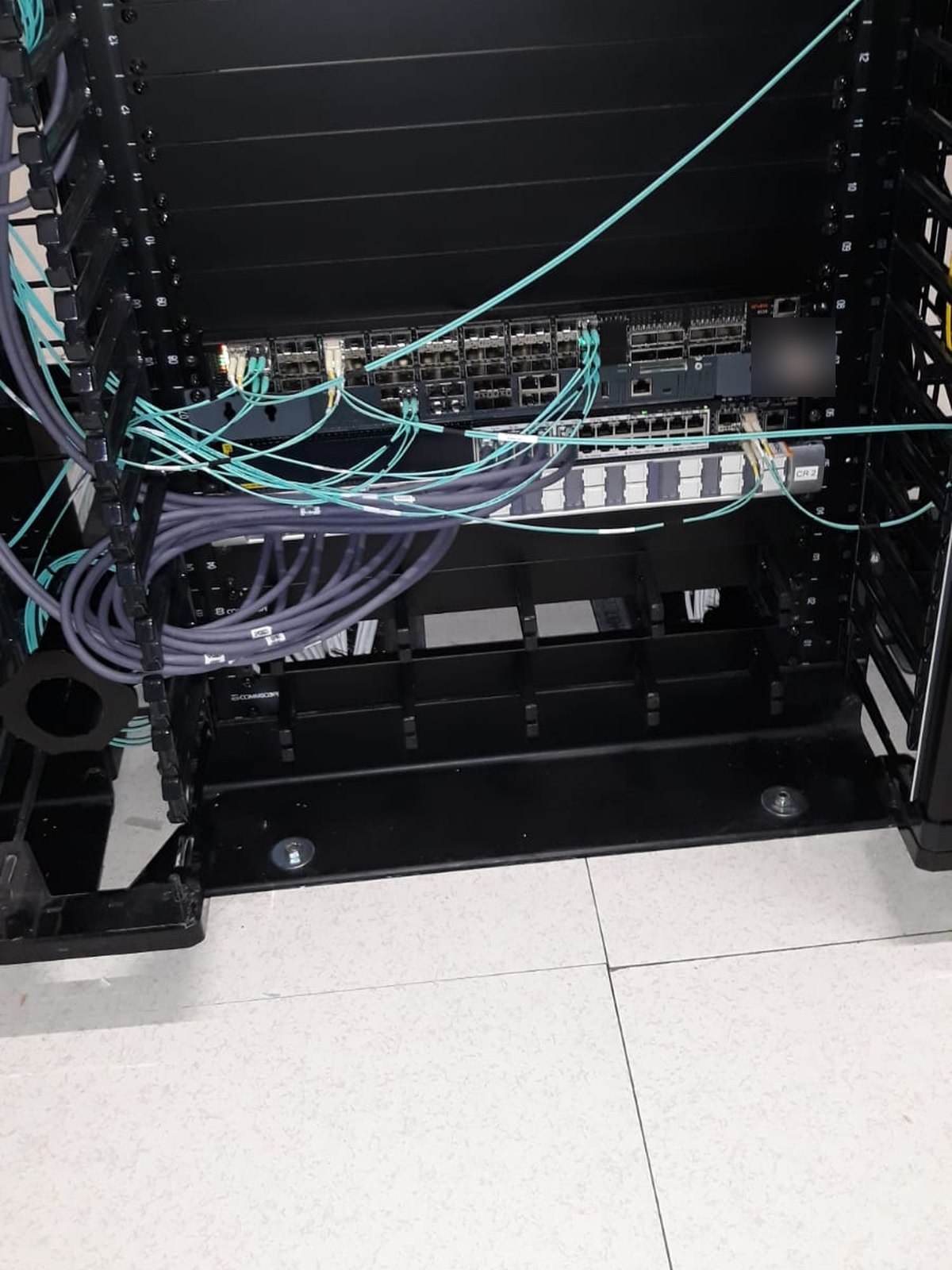 Patchcord-uri de fibră optică OM4 conectate la echipamentele din rack-ul camerei de servere